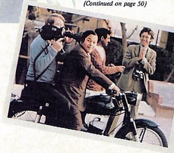 Guru Maharaj Ji revs up his motorcycle while Rennie Davis stands 'blissed out' in the background